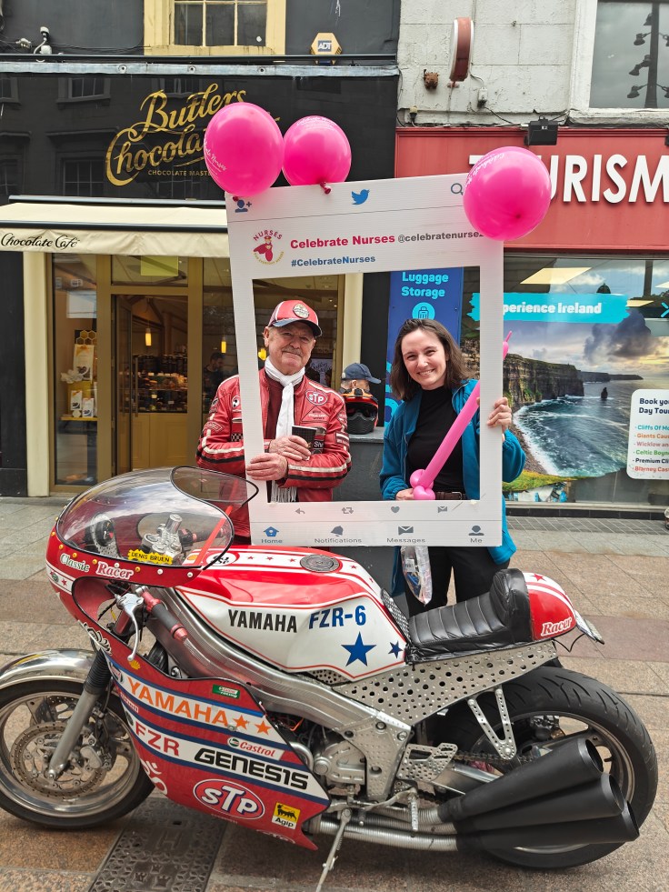 A member of the public poses with a 3Q Recruitment #CelebrateNurses photo frame beside a classic motorbike in Dublin city centre, encouraging people to thank and recognise nurses for their outstanding care.